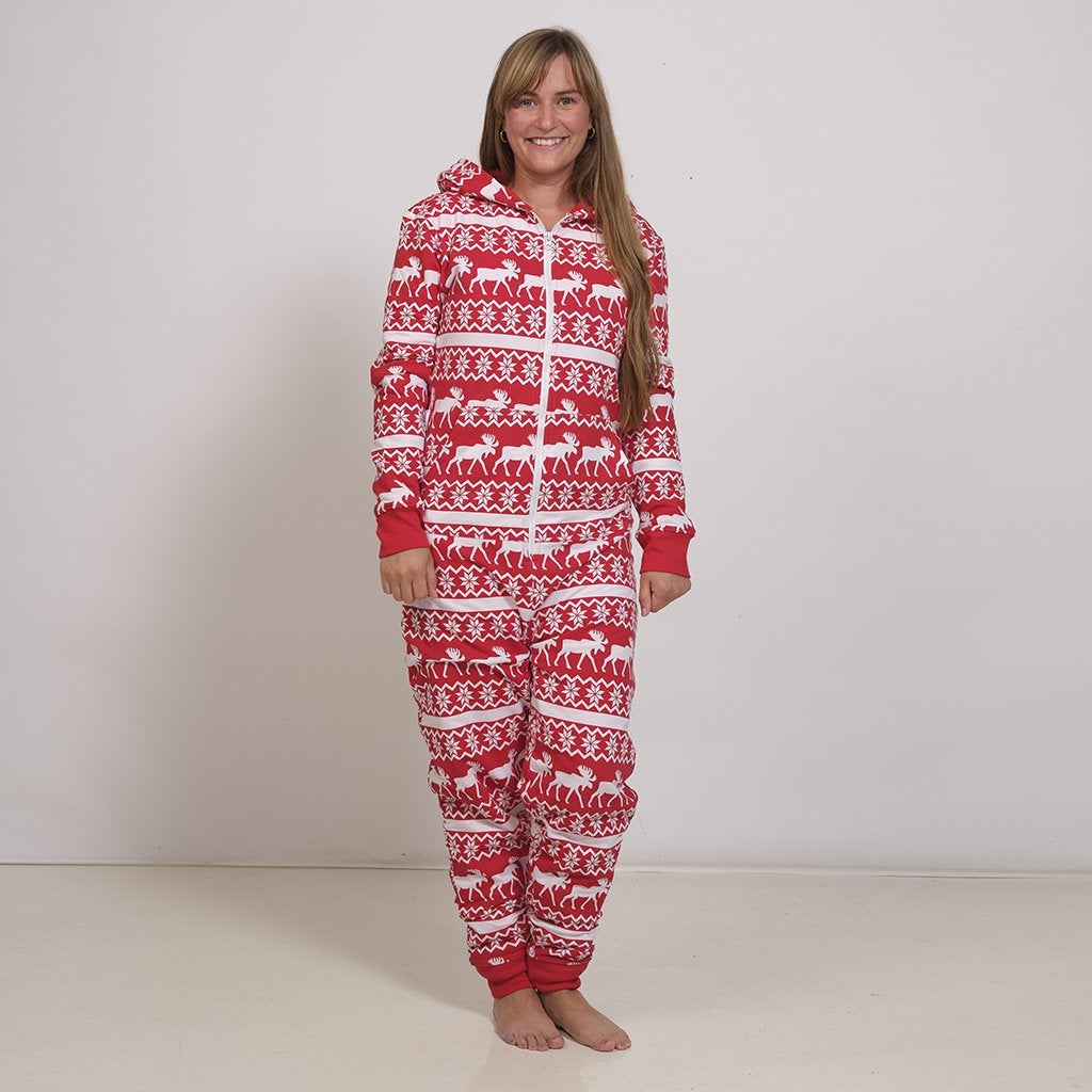 En kvinna i en röd jumpsuit med julmönster.